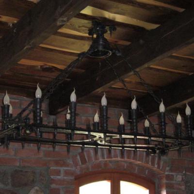 Hobby jeździectwo, czternaście punktów oświetleniowych, świecowe żarówki osadzone w przekutych trzonach spasowanych z ramą. Kute łańcuchy. Wyrób nie posiada spawów.